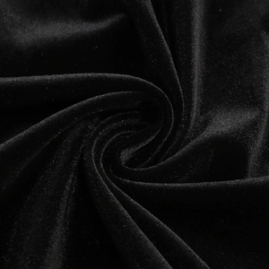 Macro shot of black velvet fabric showing soft drape and elegant light reflection