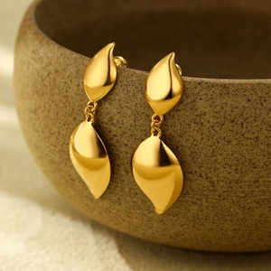 Elegant 18K gold plated titanium steel double-layer leaf earrings on a ceramic vase