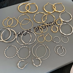 Nahaufnahme der geometrischen Creolen-Sets in Gold und Silber auf einem Display