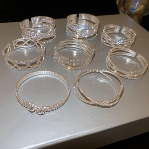 Close-up of sparkling silver bangles set with faux pearls and micro-pave crystals