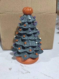 Close-up of ceramic Halloween tree featuring a pumpkin topper and multicolor lights