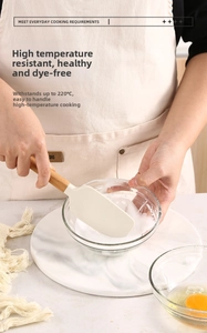 Silicone baking spatula with beech wood handle stirring in a bowl, heat resistant up to 220°C