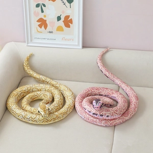 Plush snake toys in yellow and pink colors on sofa, lifelike pattern stuffed animals