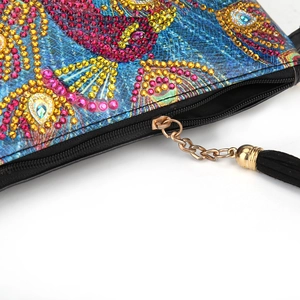 Close-up of DIY diamond painting bag with colorful peacock pattern and black tassel