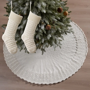 Detailed knit texture of cream Christmas stockings and tree skirt in a festive setting