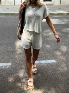 Détail de la maille ajourée du haut blanc à col en V et du short assorti en tricot