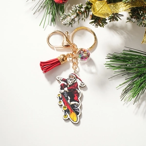 Detail of Christmas Santa skating keychain with red tassel, gold ring, and star sequin ball