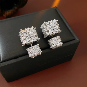 Détail des boucles d'oreilles fleur en argent avec zircone cubique sur un coffret noir