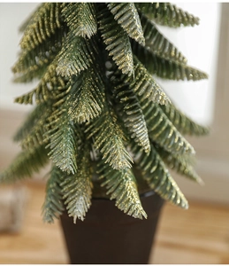 Detail of green mini Christmas tree needles with golden glitter coating and festive texture