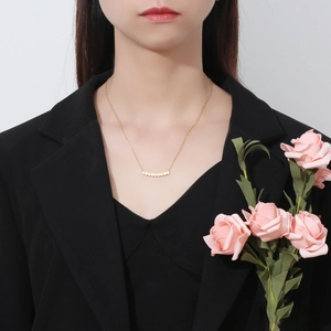 Close-up of minimalist gold honeycomb smile necklace with diamonds worn by model