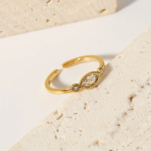 Adjustable gold plated ring with marquise cut zircon on a natural stone background