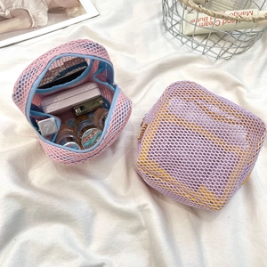 Detailed view of mesh makeup bags in pink and purple with vibrant contrasting linings