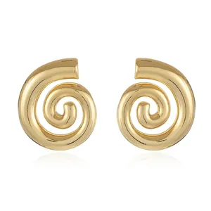 Macro view of gold-plated snail spiral earrings with high-polish geometric finish
