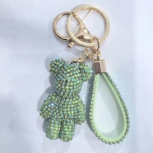 Detailed close-up of a green rhinestone bear keychain with matching crystal wrist strap