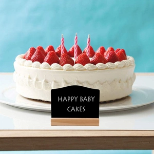 Close-up of wavy wooden tabletop mini chalkboard sign with a solid natural wood base