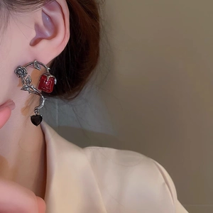 Gothic red rose stud earrings with silver vines and black heart pendant on a model