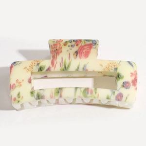 Detail of square hair claw clip with colorful floral pattern and transparent wavy teeth