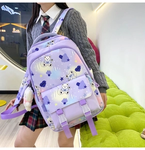 Detailed view of purple gradient backpack with cartoon bear prints and cute charms