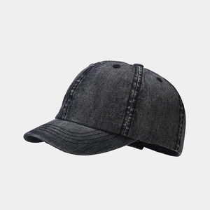 Close-up of vintage charcoal grey washed denim baseball cap with worn fabric texture