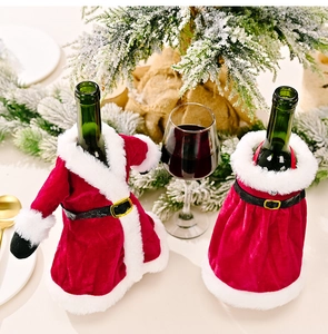Close-up of Santa style wine bottle covers in red velvet and white faux fur decor