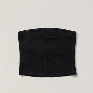 Gros plan sur le bustier noir à texture coton délavé vintage sur fond gris neutre