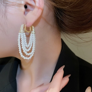 Détail de boucles d'oreilles à pampilles en perles multicouches avec zircons sur un mannequin
