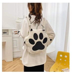 Detail of white plush cat paw backpack showing soft texture and metal strap adjustment