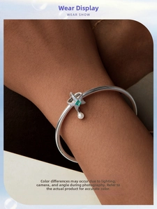 Elegant S925 silver cuff bracelet featuring a green gemstone and a white pearl charm