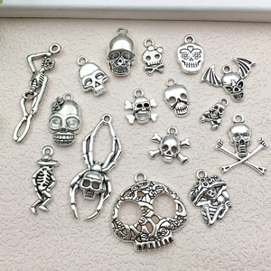 Detail of vintage silver skull charms and skeleton pendants for DIY jewelry making