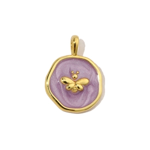 Close-up of a vintage round purple enamel pendant with a gold bee relief design