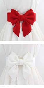 Detail of wide elastic dress belt with large decorative bow in red and white colors