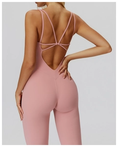Detail view of the pink yoga bodysuit featuring a multi-strap criss-cross open back design