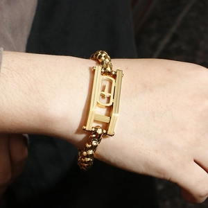 Macro detail of men's 18K gold plated hip-hop chain bracelet with rectangular hollow cross