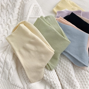 Mid-calf cotton socks in pastel colors with rib knit texture on soft background