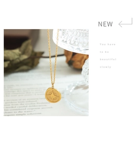 Detailed compass pendant necklace in 18K gold finish shown in a lifestyle setting