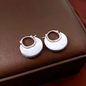 Elegant U-shaped silver hoop earrings with white mother of pearl inlay on jewelry box
