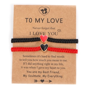 Braccialetti di coppia intrecciati a mano rosso e nero con ciondoli a cuore su carta