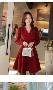 Elegant white square bag with decorative patterns held by a model in a red dress