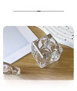 Detailed close-up of ice-textured crystal glass candle holder on a wooden table setup