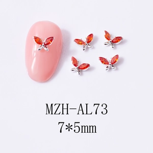 Macro detail of 7x5mm orange marquise zircon butterfly nail charms on pink nail tip