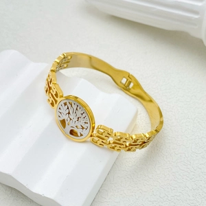 Detail of gold titanium steel bangle featuring an intricate Tree of Life cutout design