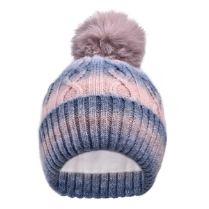 Close-up of thick fleece lining and cable knit texture on gradient winter pompom hat