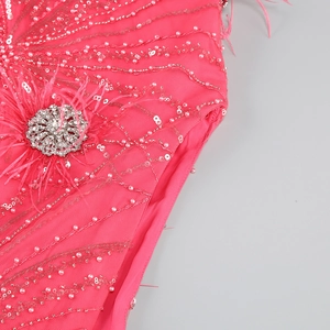 Detail of rose pink dress with silver sequins, pearls, feathers, and rhinestone flower