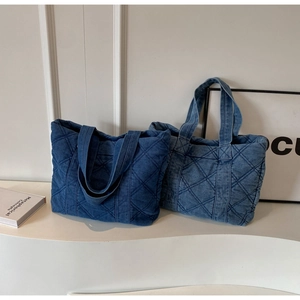 Détail de grands sacs cabas en nylon matelassé bleu foncé et clair pour femmes au style denim