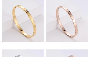 Detail of geometric clasp bracelets in gold and rose gold finish on white display