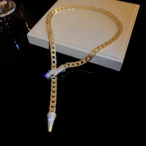 Detail of gold snake pendant with sparkling rhinestones on chunky metal chain necklace