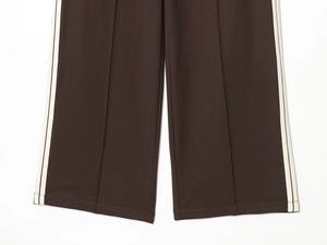 Detail of dark brown retro sweatpants with side stripes and high-quality hem stitching