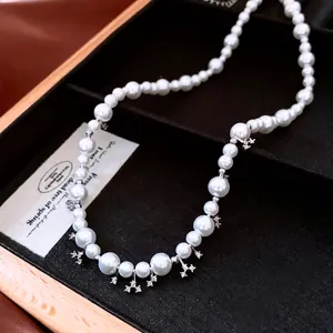 French style pearl necklace with silver star pendants on black velvet background