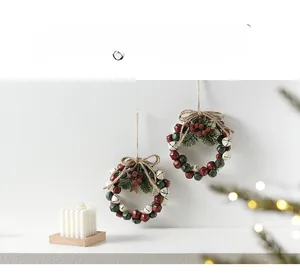Close-up of handmade Christmas bell wreath with pine needles, red berries and jute bow