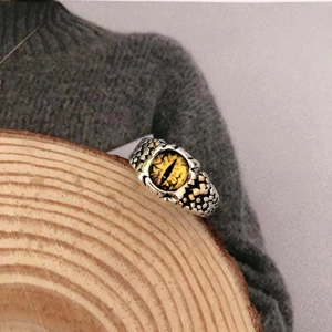 Detailed close-up of retro punk evil eye ring with yellow opal and scale texture